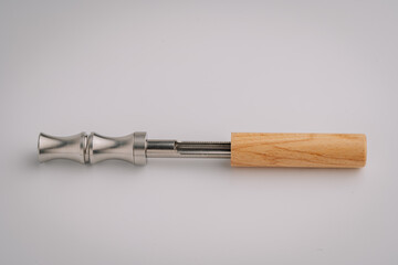 Disassembled non-electric flavor pipe showing the internal metal heating or filter chamber, laid on a clean white background..