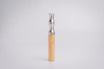 Elegant wooden and stainless steel duck call standing upright on white background, isolated for product display or hunting accessory showcase..