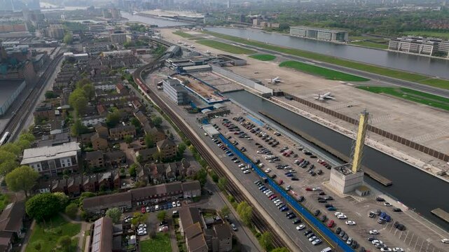Drone Reversing from London City Airport, wth runway, planes, DLR Train, Docklands