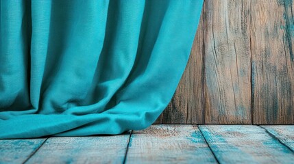 Teal curtain draped over a wooden floor