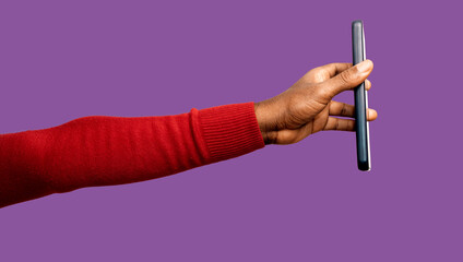 Outstretched Black African hand in red long sleeves body con sweater holding pointing mobile phone screen to the right isolated on purple background. Lift raise showing side view screen facing up