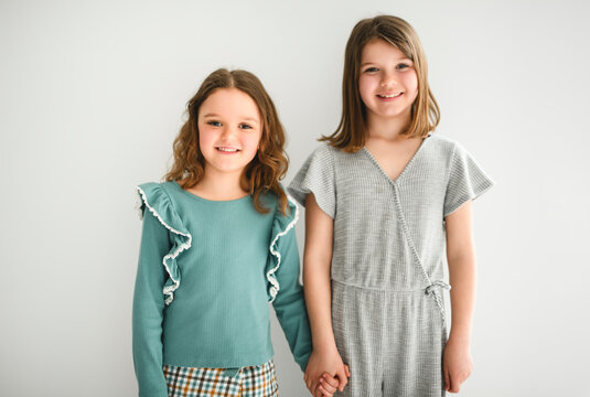 Portrait of two sisters of 6 and 8 years old over white background