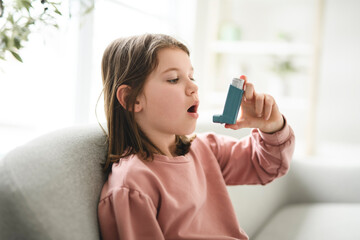 cute child having breathing problems and using an asthma inhaler