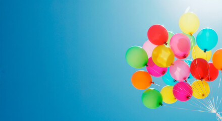 Colorful balloons floating against a bright summer sky