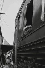 Passenger’s hand out train window in black and white