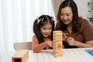 Back to School Fun and Learning. A mother and daughter enjoying a game of Jenga, fostering...