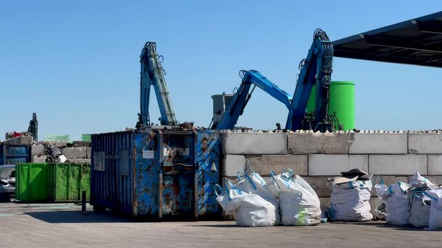 industrial car recycling facility with mechanical cranes sorting scrap vehicles and metal debris into containers, crushed cars. concept of automotive recycling, waste management