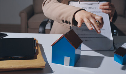Female Real Estate Broker presenting and advised to .model home and building project detail in the...