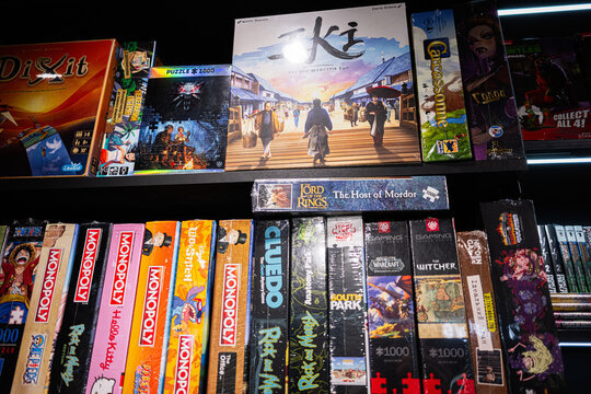 Collection of assorted board games and puzzles displayed on a shelf in a store