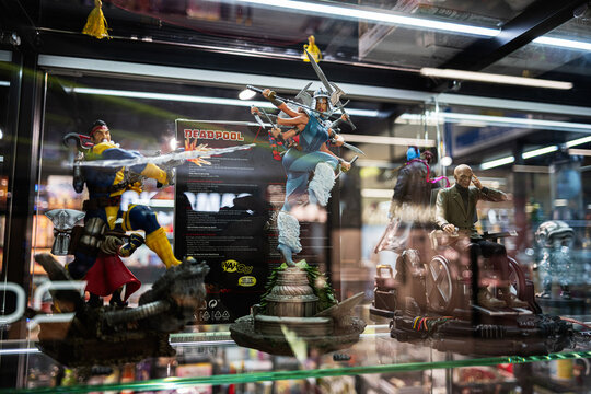 Showcase of collectible action anime figures in a display cabinet at a store