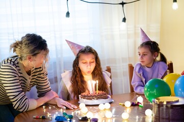 Celebration unfolds as young girl makes a wish while blowing out candles on her birthday cake...