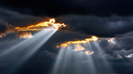 Fototapeta premium Dramatic sky filled with dark heavy clouds with bright sun rays breaking through, creating powerful and emotional contrast of light and shadow
