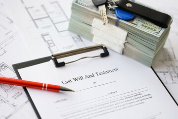 Pen and keys on Last will and testament form and planning blueprints of residential building project