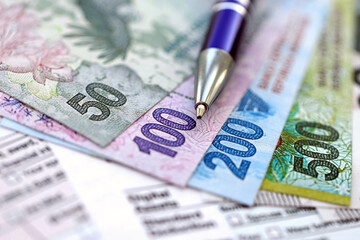 Argentine pesos money bills in big amount lies on table with pen and tax forms close up