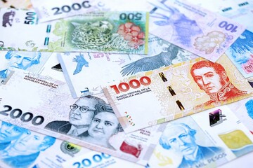 Argentine pesos money bills in big amount lies on white table close up