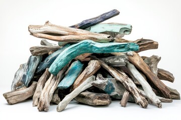 A pile of driftwood, some painted teal and blue, creating a rustic and beachy aesthetic.