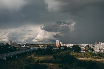 Naklejka premium Cloudy sky before rain. Clouds over houses and the city.