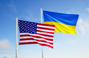 flags of ukraine and united states of america over blue sky background.
