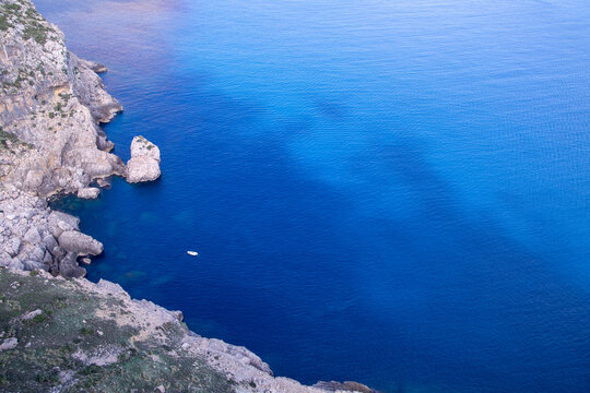 Coastal Cliffs and Vibrant Blue Sea with Rocky Shoreline