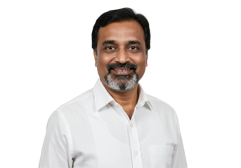 A middle-aged South Asian man with a beard smiles warmly while wearing a white collared shirt against a plain black studio background.