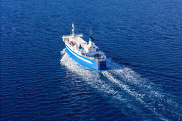 Passenger ferry sailing across the Aegean Sea, connecting remote Greek islands, aerial drone video