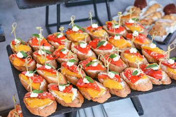 Buffet food for party decorated with fresh plants. Sandwiches with cheese and ham on table.  Catering buffet food indoor in luxury restaurant with meat and vegetables. Buffet table with delicacies