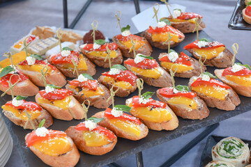 Buffet food for party decorated with fresh plants. Sandwiches with cheese and ham on table. Catering buffet food indoor in luxury restaurant with meat and vegetables. Buffet table with delicacies