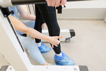 Therapist assisting patient during supported walking exercise in a rehabilitation clinic