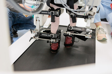 Child on robotic gait trainer during walking therapy session at pediatric rehabilitation center