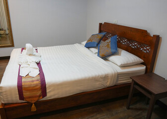 wooden bed with pillows in hotel room
