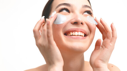 Close-up of a young woman with natural makeup, healthy fresh skin and collagen eye patches. Morning...