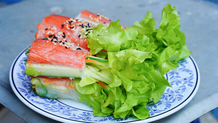 Fresh vegetable salad roll with crab stick eating with spicy salad dressing