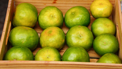 A wooden crate filled with fresh, juicy oranges, showing the bright colors of the different parts.