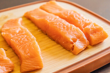 Close-up of fresh raw salmon fillets placed on a wooden cutting board
