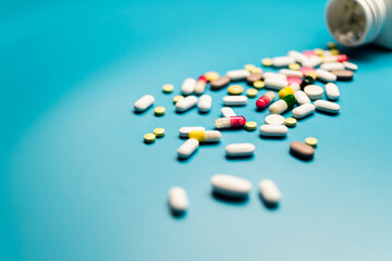 Colorful Pills and Capsules on Blue Background, Top-Down View