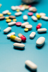 Colorful Pills and Capsules on Blue Background, Top-Down View