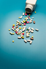 Colorful Pills and Capsules on Blue Background, Top-Down View