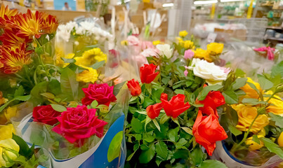 Fresh flower bouquets in vivid colors including roses and chrysanthemums displayed in a store,