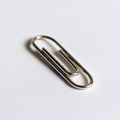 A silver clip with a silver paper clip on it