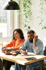 Couple engages in productive remote work at a cozy cafe space together