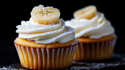 Two delectable banana cupcakes topped with creamy frosting and sprinkled with powdered sugar