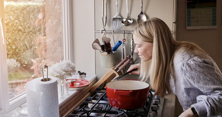 Fototapeta na wymiar Woman, smell and cooking at stove pot or warm winter meal, stew dinner or smile in kitchen. Female person, gas appliance or prepare nutrition eating as soup diet or fresh taste, hungry health in home