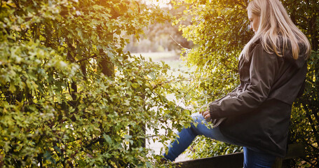Countryside, fence and woman in nature walking for wellness, fresh air and relax outdoors. Trees, health and person in field, meadow and farm for adventure, peace and freedom in natural environment