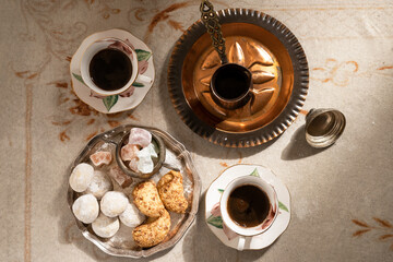 Turkish coffee with traditional sweets on antique carpet
