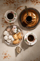 Turkish coffee with traditional sweets on antique carpet
