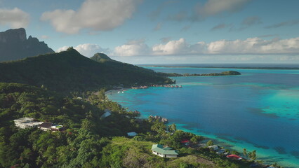 Aerial drone of Bora Bora beauty, green mountain, turquoise lagoon, overwater bungalows, and...