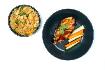 Garlic fried rice with fried mackerel in teriyaki sauce, carrots and cucumber on white background isolated. Top view.