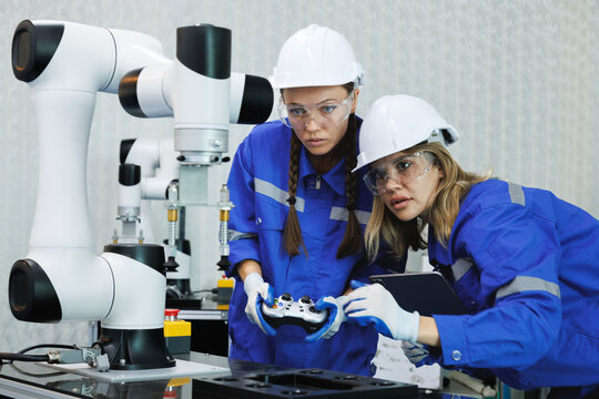 female automation machine engineer student study and inspection control robot arm machine in university lab or factory workshop. ai robot technology new innovation trend of manufacturing in industrial