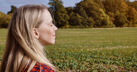 Breathe, relax and woman with eyes closed in countryside, nature or holiday travel, vacation or farm. Meditation, person at field and calm, peace and summer freedom, fresh air and health or wellness