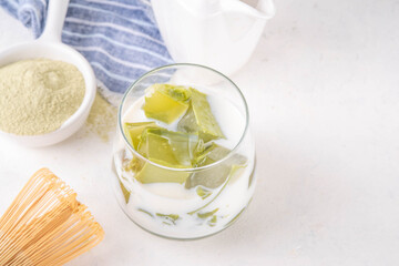Matcha jelly latte, iced milky drink with green matcha tea jellatin cubes, trendy refreshing Iced non-caffeine healthy drink